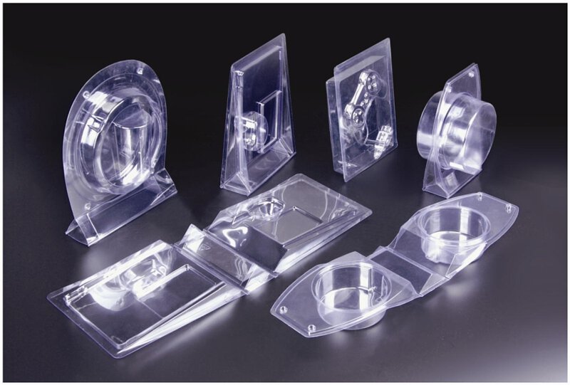 A collection of clear plastic blister packages in different shapes and sizes displayed on a dark background.