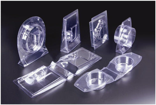 A collection of clear plastic blister packages in different shapes and sizes displayed on a dark background.
